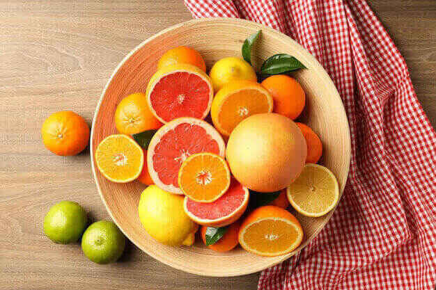 different citrus fruits wooden table top view