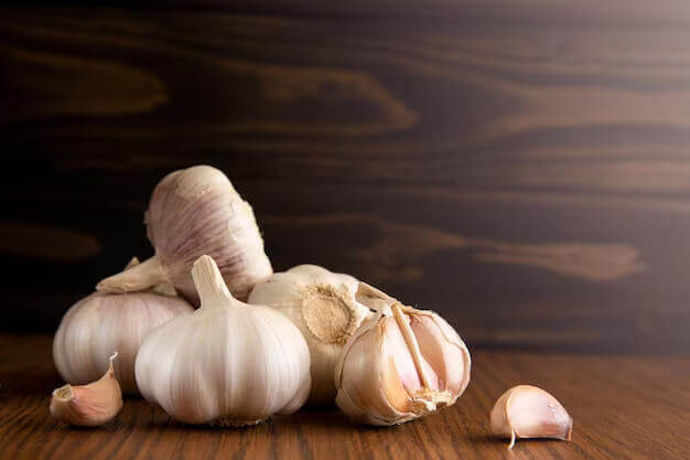garlic cloves bulb dark wooden table background copy space