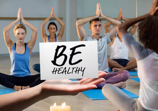 hand holding card with text be healthy yoga class